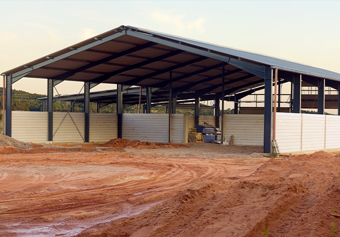 Metal buildings and roofing supplier in Central, LA Walker Metals. Image of new agricultural building being constructed.