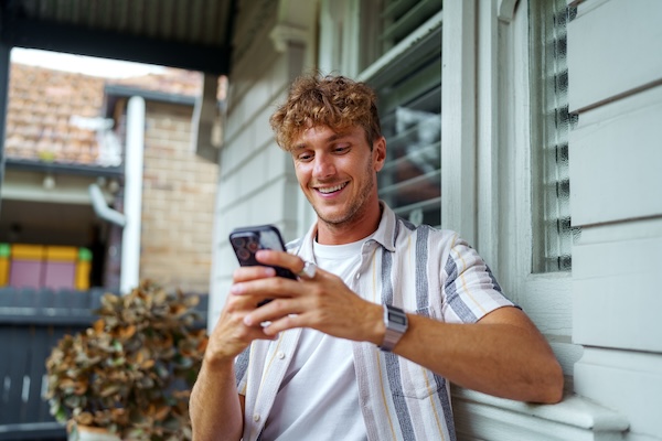 man talks on phone under metal roof wondering do metal roofs block cell service